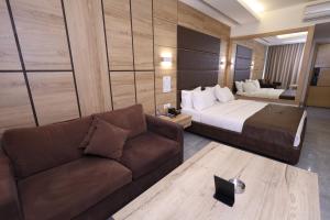 Habitación de hotel con cama y sofá en Ibiza Hotel en Jounieh