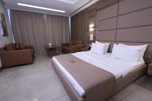 um quarto de hotel com uma cama grande e cadeiras em Ibiza Hotel em Jounieh