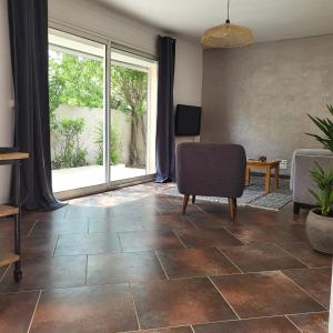 a living room with a chair and a large window at Maison 6 personnes 3 chambres Aéroport-Plages in Marignane +11 photos