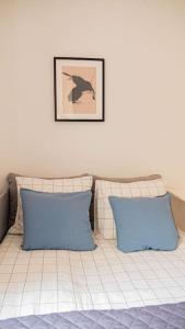 ワルシャワにあるMini kawalerka w samym Centrum Warszawyのベッド1台(青い枕2つ付)、壁に絵が描かれています。