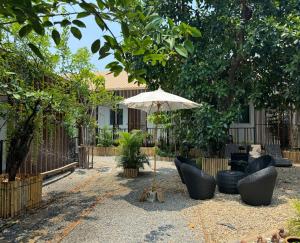 清邁的住宿－Proud Chiang Mai Poshtel，庭院配有桌椅和遮阳伞。
