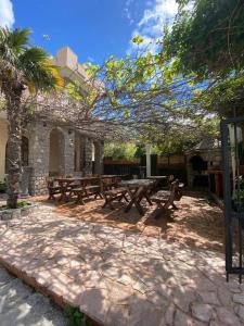 a patio with wooden picnic tables in a building at Violit Apartments&Restaurant in Sutomore