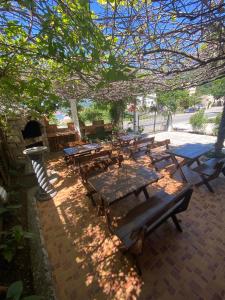 a group of picnic tables sitting under a tree at Violit Apartments&Restaurant in Sutomore