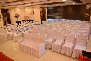 un salón de banquetes con sillas y mesas blancas en HOTEL MAA LAXMI PALACE en Deoghar