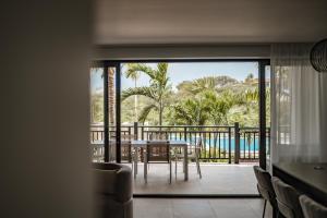 Habitación con mesa y balcón con vistas. en Blue Bay Curaçao Golf & Beach Resort, en Willemstad