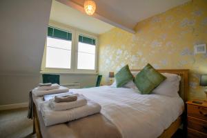 ein Schlafzimmer mit einem Bett mit zwei Handtüchern darauf in der Unterkunft Sinai House in Lynton