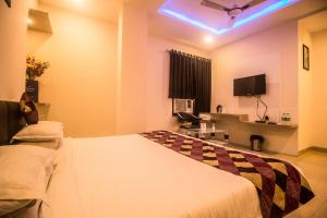 um quarto de hotel com uma cama e uma televisão em Capital O 5764 A Park Hotel em Gwalior