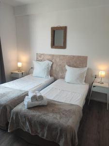2 camas con toallas encima en una habitación en L'Aiglon Bylitis, en Porto Vecchio
