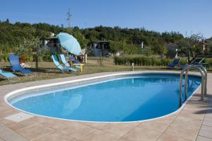 a large swimming pool with chairs and an umbrella at Mobile Homes Romantik in Labin