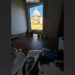 a magazine sitting on a table next to a window at 99 Scalini in Naples