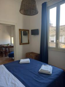 a bedroom with a bed with blue sheets and a window at 99 Scalini in Naples