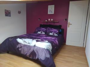 een slaapkamer met een paars bed met zwanen erop bij Studio cosy avec terrasse et jacuzzi en plein air in Rians