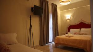 - une chambre avec 2 lits et une télévision sur un tripod dans l'établissement Hotel Viky, à Sarti