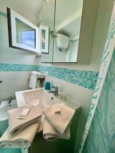 ein Badezimmer mit einem Waschbecken, einem Spiegel und Handtüchern in der Unterkunft Ponza Vista Mare in Ponza