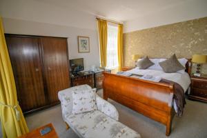 1 dormitorio con 1 cama y 1 silla en Sinai House en Lynton