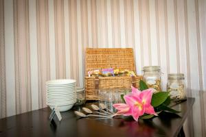 a table with a basket and a pink flower on it at Sinai House in Lynton