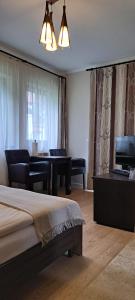 een slaapkamer met een bed en een woonkamer met een piano bij Transylvania Villa & Spa in Gosau