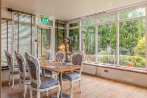 comedor con mesa, sillas y ventanas en Muthu Newton Hotel (Near Inverness Airport), en Nairn