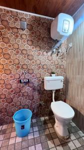 La salle de bains est pourvue de toilettes et d'un seau bleu. dans l'établissement Mysa Maya Homestay, à Darjeeling