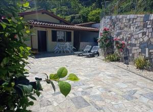 a patio with two chairs and a house at Retiro Da Montanha - Gerês in Geres