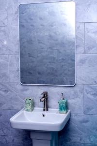 a bathroom sink with a mirror and two tissue boxes at Peacefull home Too in Kampala +26 photos