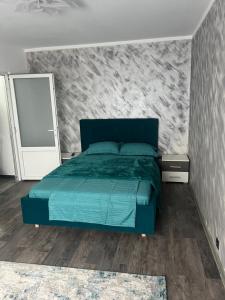 a bedroom with a green bed and a wall at Green Apartament in Târgu Jiu +4 photos