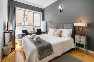 a bedroom with a bed and a desk and a window at GuestReady - Gold Leaf in Porto