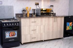 a kitchen with a counter with a microwave and a stove at Peacefull home Too in Kampala