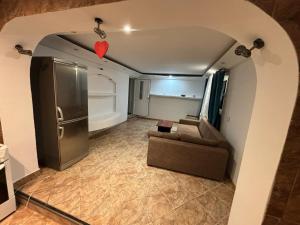 ein Wohnzimmer mit einem Sofa und einem Kühlschrank in der Unterkunft Casa Anisia by Hypnotic in Piteşti