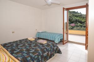 a bedroom with two beds and a sliding glass door at Monterosso view apartment 5 Terre in Monterosso al Mare