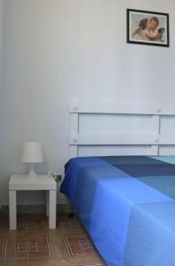 - une chambre avec un lit bleu et une table de chevet dans l'établissement Appartamento Stella Di Mare, à Campomarino
