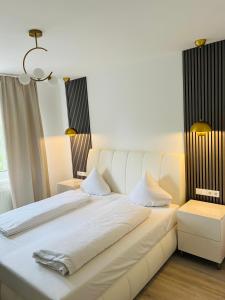 a white bed with white sheets and pillows at Ferienhaus Doina in Gehlberg