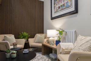 a living room with chairs and a table and a radiator at Kings Road Suites in Brighton & Hove