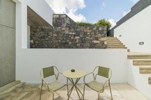 zwei Stühle und ein Tisch auf einer Terrasse in der Unterkunft Xª Deluxe Apartments in Ribeira Grande