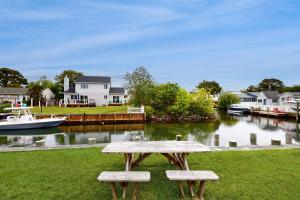 a picnic table sitting on the grass next to a river at Dockside Daydreamin' in Ocean City