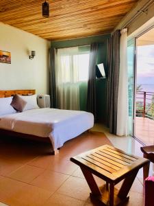 Kalangala的住宿－The Address Resort，一间卧室配有一张床、一张桌子和一个窗户。