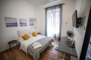 een slaapkamer met een bed met gele kussens en een televisie bij Cosmo GuestHouse in Rome