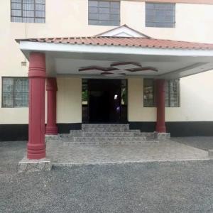 un edificio con columnas rojas y un edificio con puerta en MUSEUM VIEW HOTEL KISUMU CITY-MILIMANI en Kisumu
