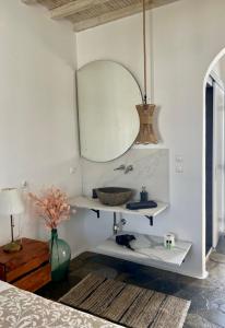 a bathroom with a sink and a mirror on a wall at Vougli View Mykonos in Drafaki