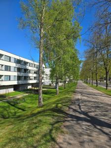 una carretera arbolada frente a un edificio en Avara ja kodikas huoneisto parvekkeella, en Heinola