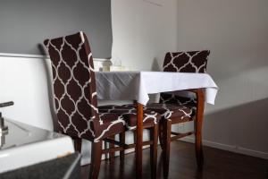 mesa de comedor y 2 sillas con mantel blanco en Motel Deblois en Sainte-Anne-de-Beaupré