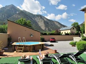 a group of people sitting in lawn chairs in front of a pool at Gîtes la Mexicaine in Jausiers