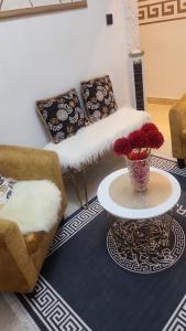 ein Wohnzimmer mit 2 Sofas und einem Tisch mit Blumen in der Unterkunft Luxueux platinium in Libreville