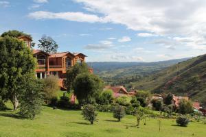 una casa en una colina en un campo verde en Suites Arcoiris, en Villa de Leyva
