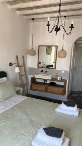 a bedroom with a mirror and a bed with towels at Vougli View Mykonos in Drafaki