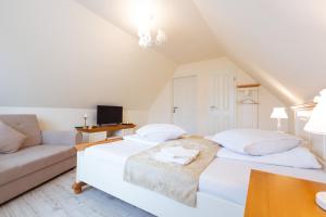 a white bedroom with a bed and a couch at Green Garden Avrig in Avrig +93 photos