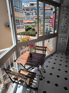 a wooden table on a balcony with a vase of flowers at Apartamento Tango in Fuengirola