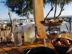 a table with glasses of wine and a basket of food at Le Cochat in Andernos-les-Bains