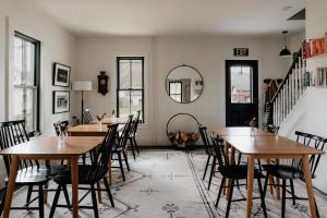 una sala da pranzo con tavoli e sedie in legno di The Yarra a Roscoe