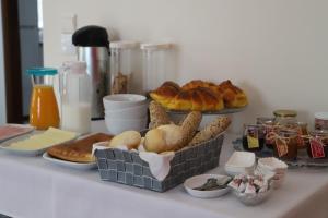 a table topped with baskets of bread and pastries at Casa Vale do Douro in Mesão Frio